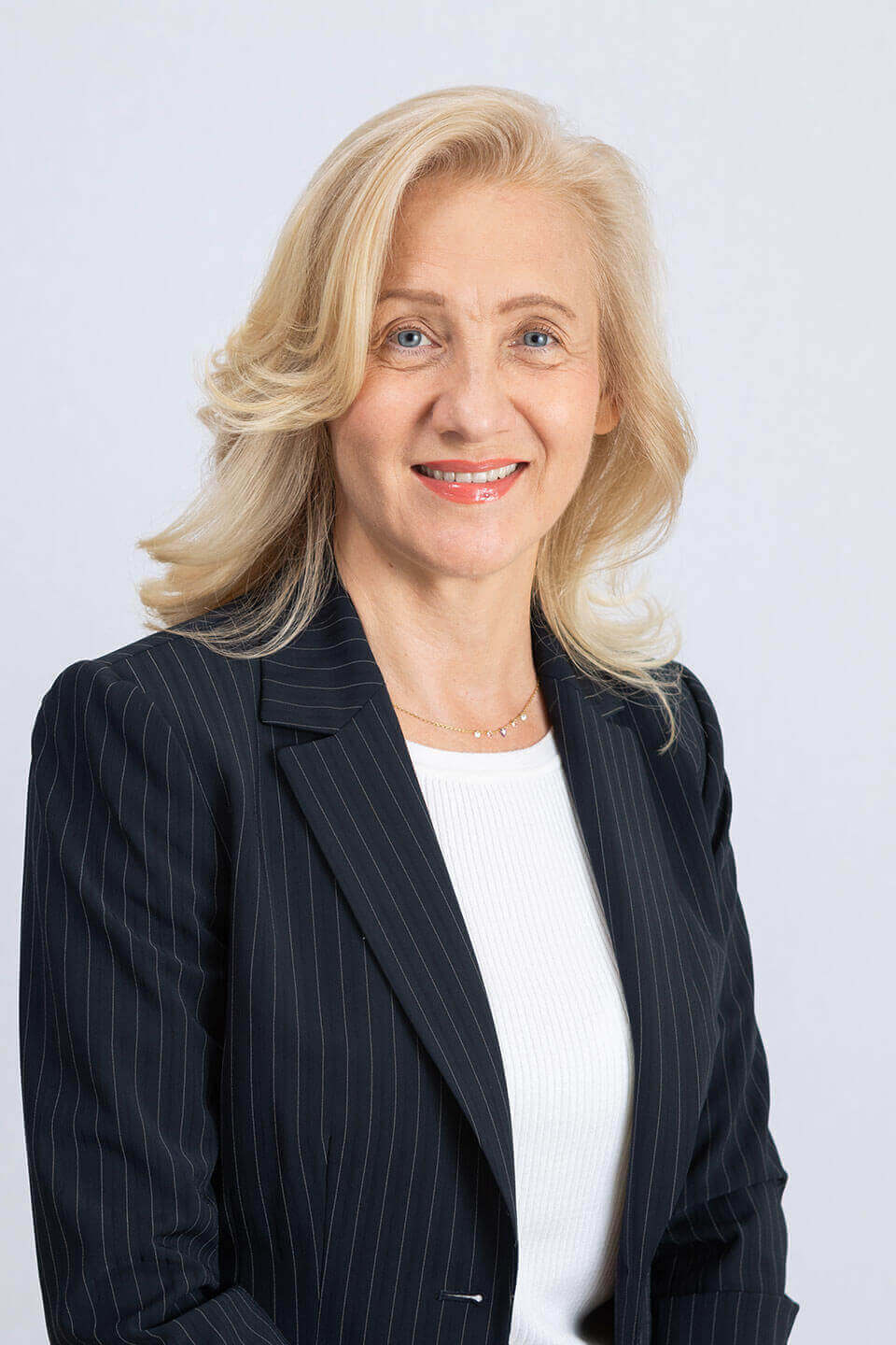 Alison Hodges, PMHNP, smiling in a white blazer and black top.