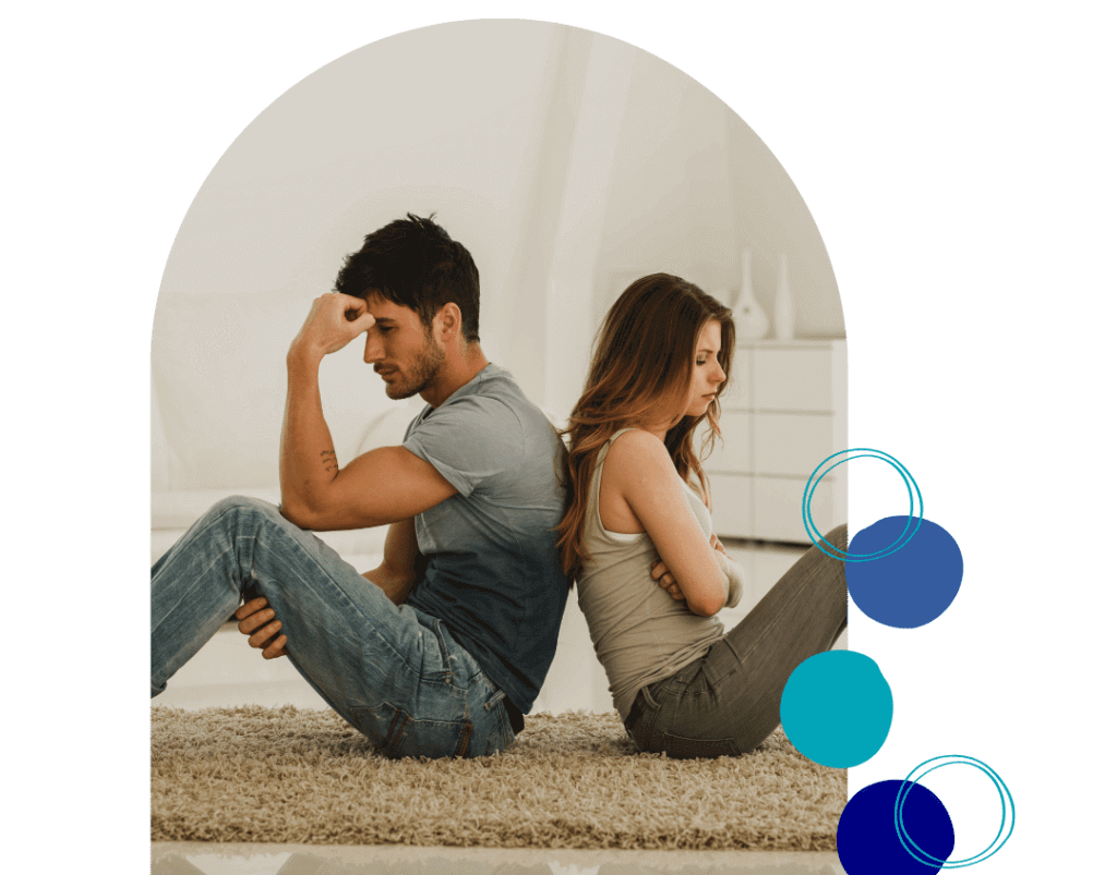 2 A couple sitting back-to-back on the floor, looking distressed, symbolizing challenges addressed in Couples Therapy in Altamonte Springs.