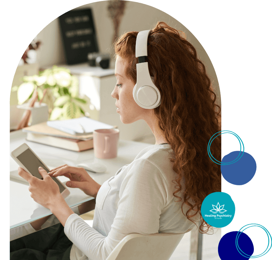 adhd psychiatrist altamonte springs, florida-1 Young woman with headphones using a tablet at a desk, representing ADHD treatment in Altamonte Springs.