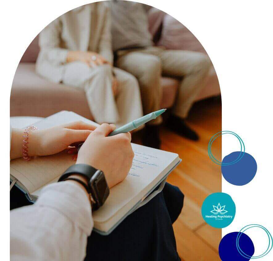 A focused session at Healing Psychiatry of Florida, showcasing a therapist's hands taking notes during a patient consultation, emblematic of personalized psychiatry and therapy services in Casselberry, Florida