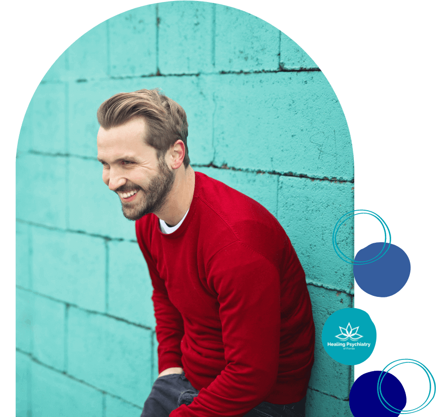 Man smiling while leaning against a turquoise wall, representing positive results of bipolar disorder treatment in Altamonte Springs.
