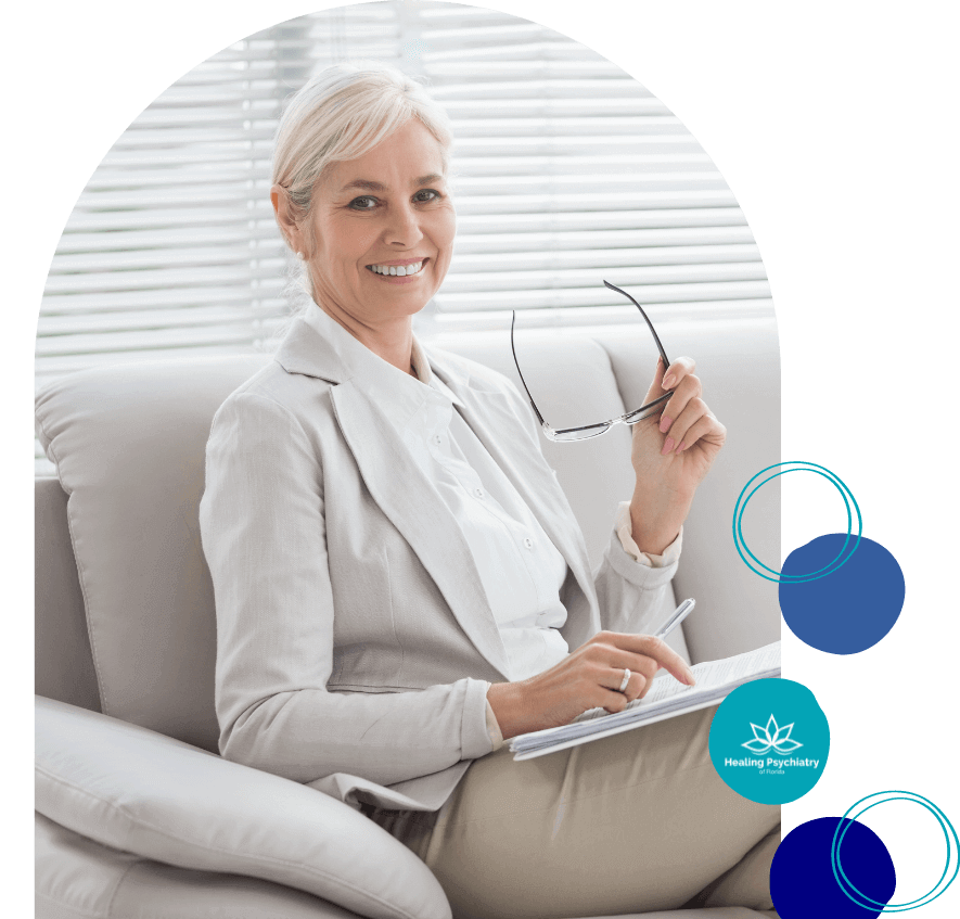 Maitland Psychiatric Services Smiling, professional psychiatrist from Maitland Psychiatric Services, poised with a notepad and glasses, embodies the trusted and welcoming atmosphere of Healing Psychiatry of Florida.