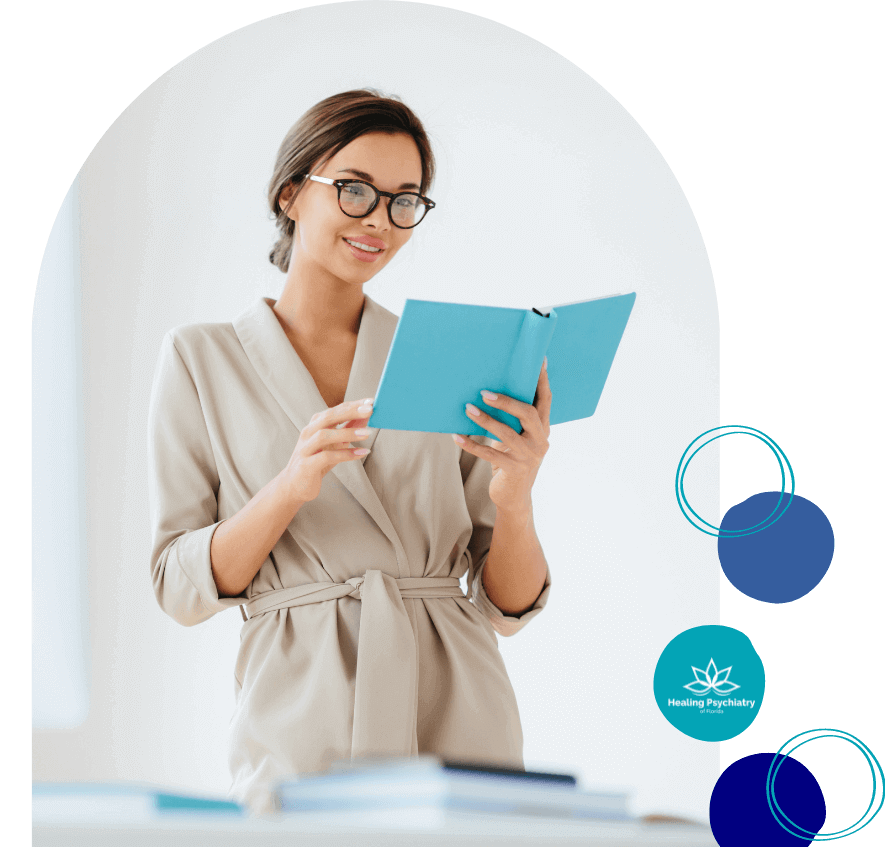 A poised woman in smart casual attire is reading a book, portraying an image of focus and learning