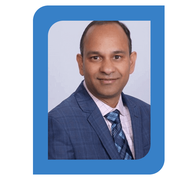 Headshot of Dr. Shivam Dubey, MD, Medical Director, and Psychiatrist, wearing a blue plaid suit, checkered shirt, and patterned tie