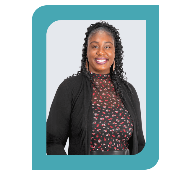 Headshot of Fauzia Adeyemo, LMHC-I, wearing a floral-patterned top and black cardigan
