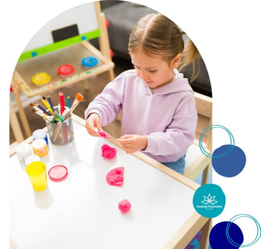 A young child playing with colorful playdough during therapy.