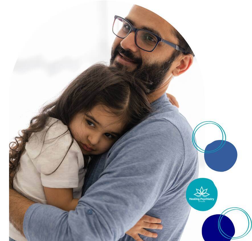 children therapy (6) A father holds his young daughter in his arms as she leans against him, looking calm and secure.