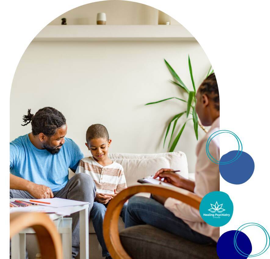 A young boy sits between his father and a therapist during a family therapy session, with supportive body language and open dialogue.