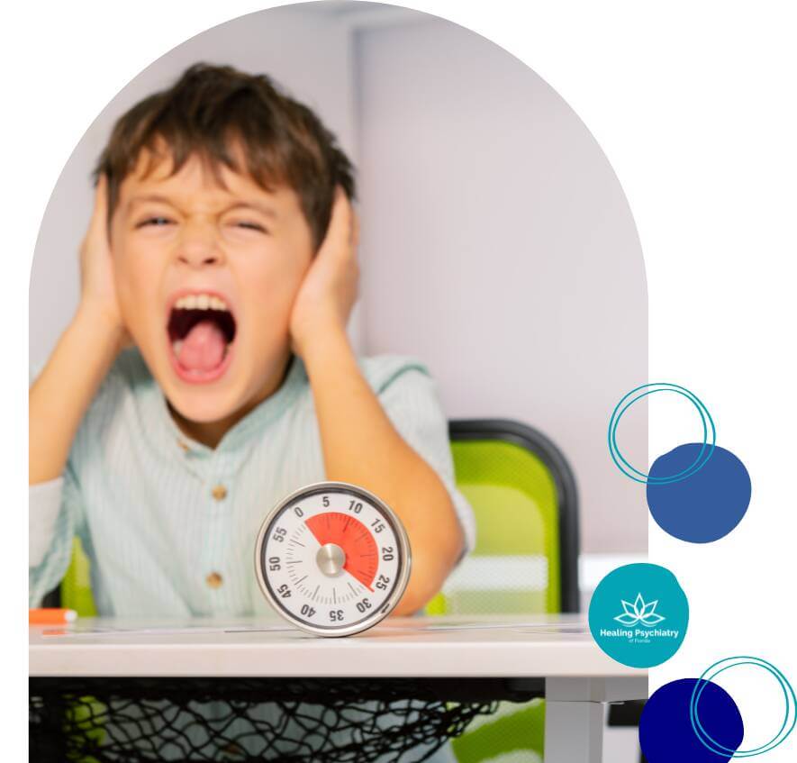 A child is screaming and covering his ears, clearly distressed, with a timer placed on the table in front of him, symbolizing frustration or stress.