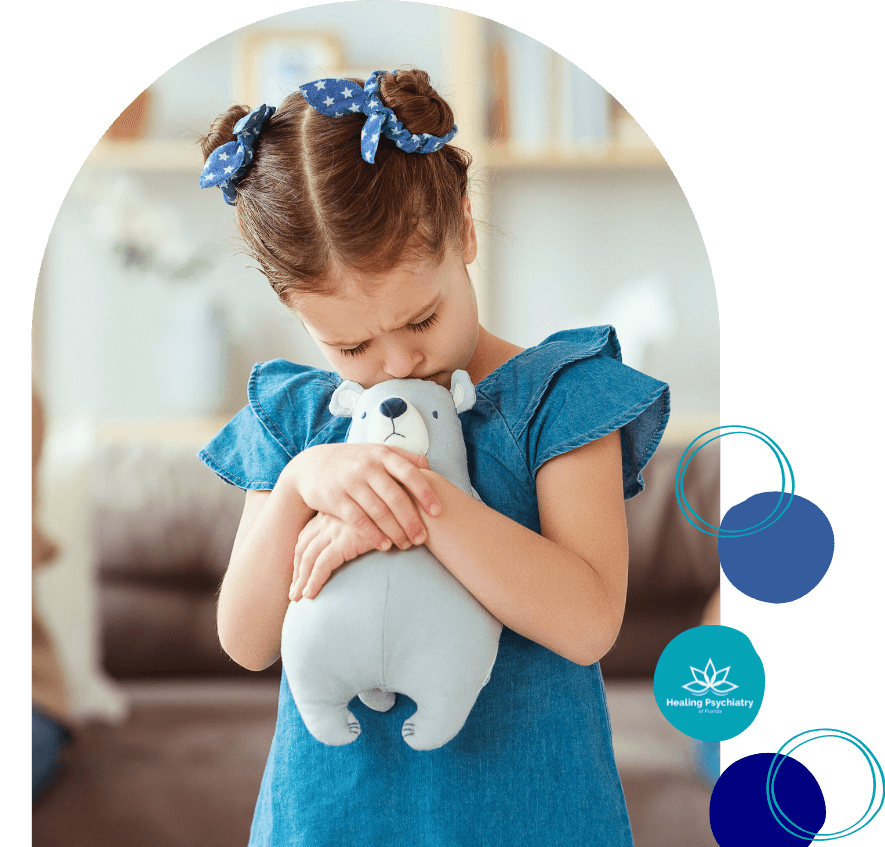 Child struggling with emotions during parents' divorce, hugging stuffed animal for comfort, representing children’s therapy and counseling services for divorce at Healing Psychiatry of Florida.