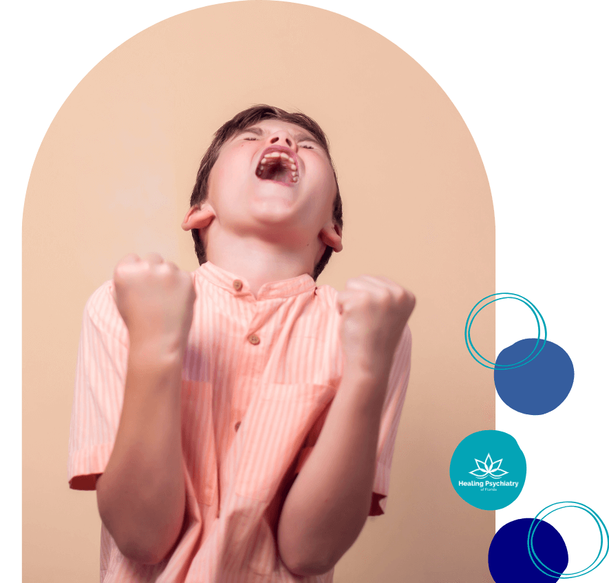 A young boy in a striped peach shirt stands with his fists clenched and mouth wide open, expressing intense frustration or anger. His head is tilted back and eyes closed, emphasizing the emotional outburst. The image features the "Healing Psychiatry of Florida" logo.